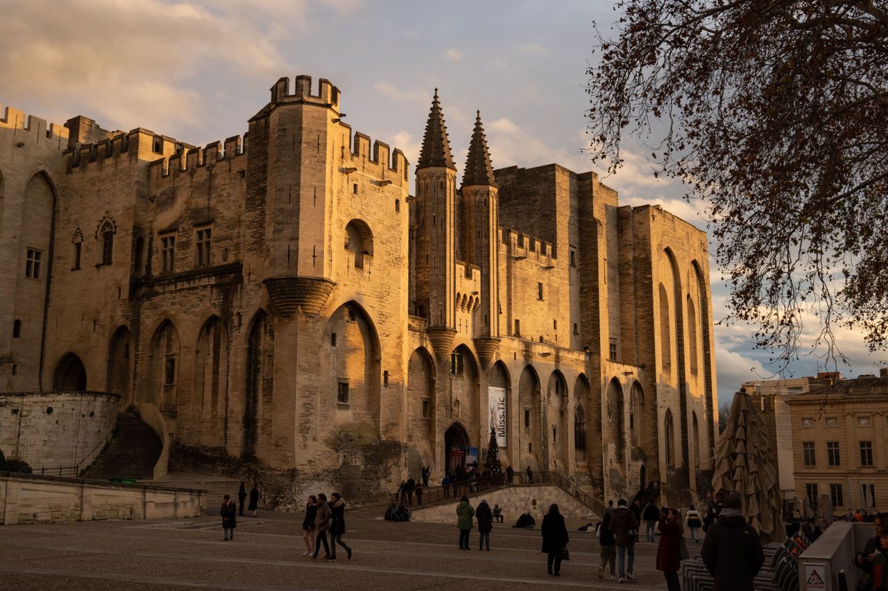 Stunning view of Palais des Papes in Avignon during sunset, showcasing Gothic architecture.