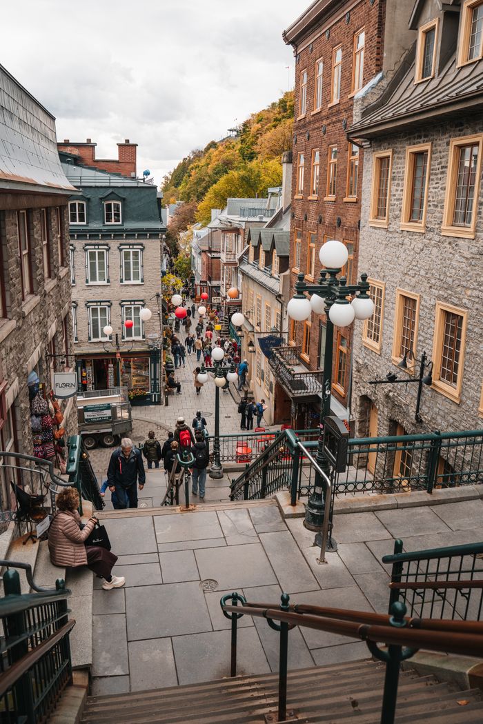 Explore the vibrant street life in Old Quebec City with autumn colors and historic architecture.