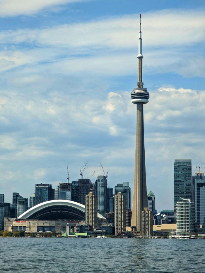 Stunning view of Toronto's skyline with the iconic CN Tower and Rogers Centre under a cloudy sky.